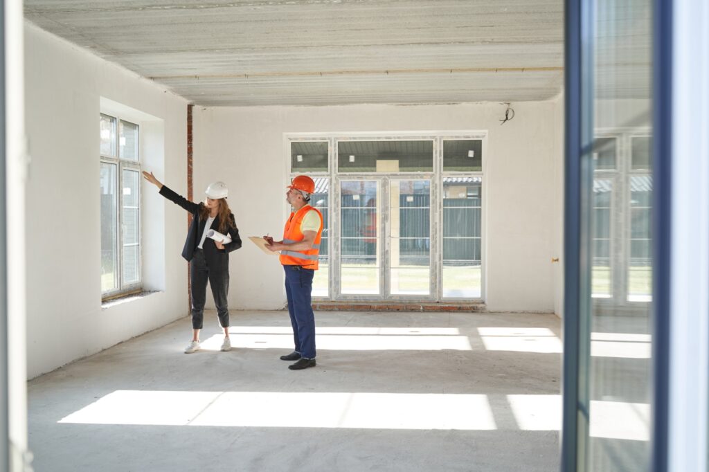 Builder taking notes from female engineer about window